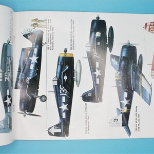May include: A collection of five vintage aircraft illustrations, including a blue and white Grumman F6F Hellcat, a red and white Grumman F6F Hellcat, and three other blue and white Grumman F6F Hellcats. The illustrations are detailed and include markings and numbers.