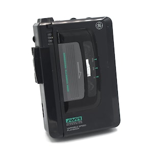 May include: A black cassette recorder with a digital counter and a green AVR Automatic Voice Recording label. The recorder has a variable speed playback feature.