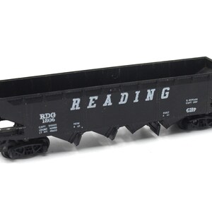 May include: Black model train car with the words "READING" and "RDG 1806" printed on the side. The car has a capacity of 100,000 lbs and a light weight of 41,000 lbs.