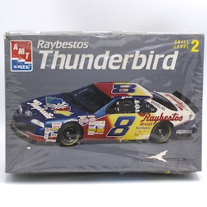 May include: A model kit box for a Raybestos Thunderbird race car. The box features a colorful image of the car with the number 8, and the text "Raybestos Thunderbird" in large letters. The box is labeled "Skill Level 2".