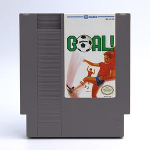 May include: A white ceramic mug with a black handle and the text "But First, Coffee" in a bold, black font. The mug is set against a neutral background, highlighting its simple design.