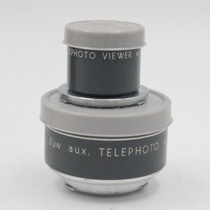 May include: A gray and silver Sun aux. Telephoto lens with a gray and silver Sun Photo Viewer lens attached to the top.