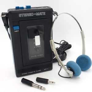 May include: A black cassette player with the text "STEREO-MATE" and "STEREO CASSETTE PLAYER SCP-4" on the front. The player has a blue eject button and a volume knob. It comes with a pair of blue headphones and two black audio cables.