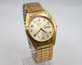 Vintage Pulsar Men's wristwatch gold tone white analog dial weekday calendar date elastic band mid century style Japan Movement