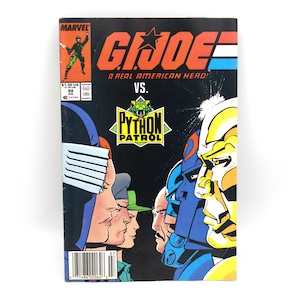 May include: A vintage G.I. Joe comic book featuring a vibrant cover with the text "G.I. Joe: A Real American Hero!" and "Python Patrol." The comic has a black background with colorful illustrations of characters in action. The Marvel logo is visible.