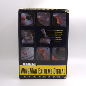 Puede incluir: Caja de joystick Logitech Wingman Extreme Digital negra y gris. La caja presenta im&aacute;genes en primer plano de las caracter&iacute;sticas del joystick, incluido el interruptor de sombrero de 4 v&iacute;as, los botones de goma, el gatillo de disparo r&aacute;pido y el agarre esculpido. Se muestra el texto "WINGMAN EXTREME DIGITAL".