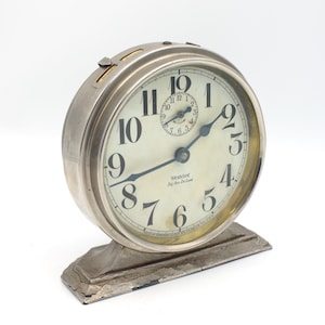 May include: A silver Westclox Big Ben alarm clock with black numbers and hands. The clock has a round face and a silver base.