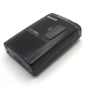 May include: Black Sony TCS-580V stereo cassette-corder. The portable recorder has a speaker grill, a large play button, and the word "SONY" printed on the top. The model number and "V-OR" are also visible. The device is on a white background.