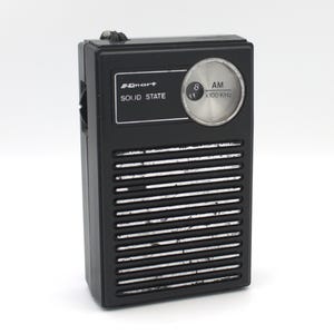 May include: A black and silver Smart brand AM radio with a solid state design. The radio has a dial with numbers 8 and 11 and the text "AM x 100 kHz".