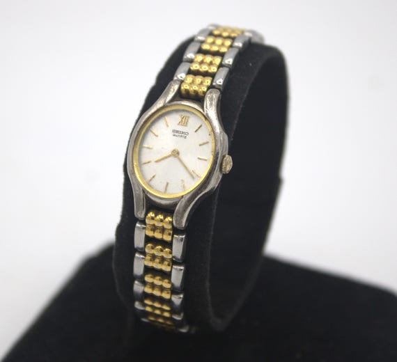 Vintage Seiko woman's wristwatch analog dial polished silver chrome and gold tone quartz watch Japan 1980s