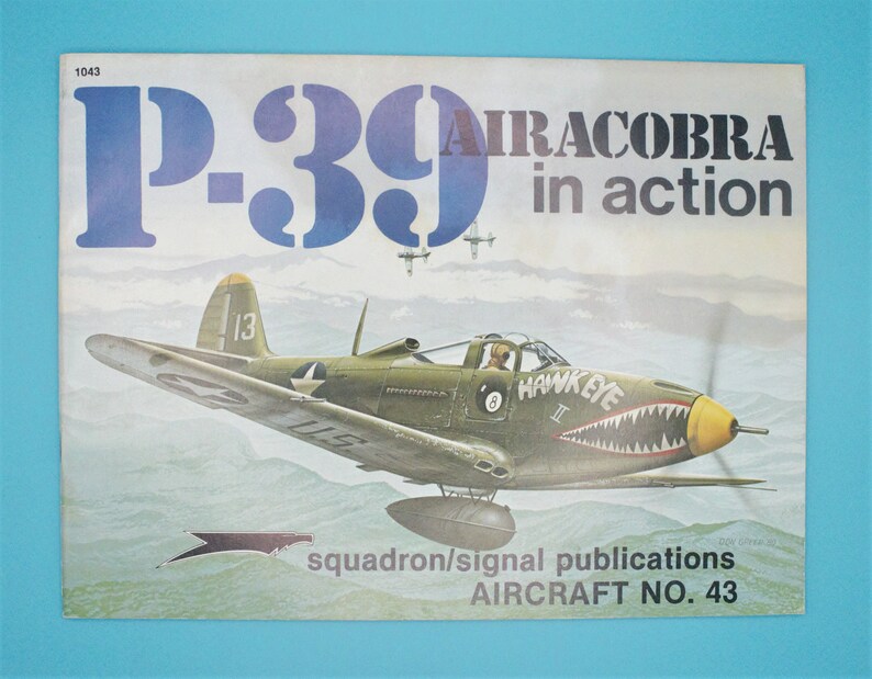 May include: A vintage book cover featuring a green and yellow P-39 Airacobra fighter plane in flight. The cover is titled "P-39 Airacobra in action" and includes the text "squadron/signal publications AIRCRAFT NO. 43".