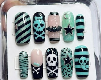May include: A set of press-on nails with various designs. The nails feature black and teal stripes, skulls, bats, stars, and leopard print patterns. Some nails have a matte finish, while others have a glossy finish. The text "Thank you for your order" is visible.