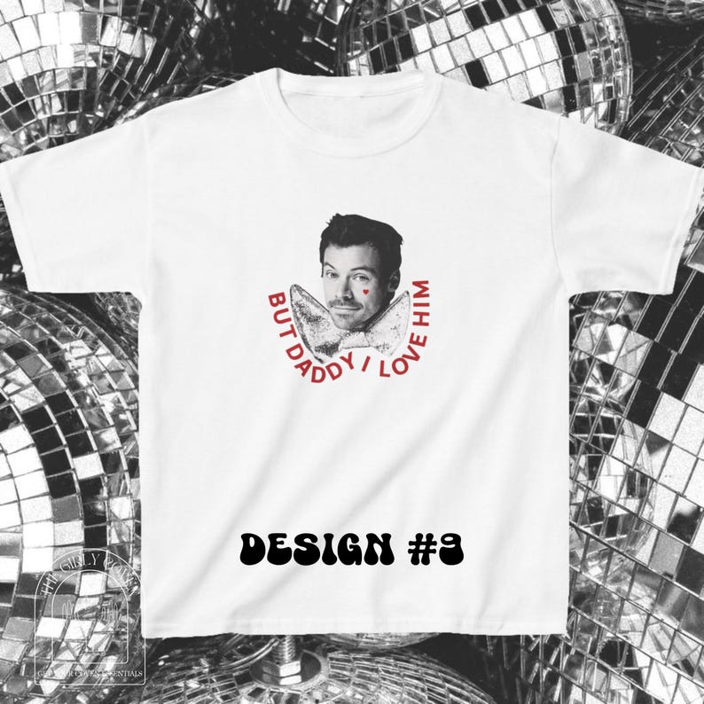 Puede incluir: Una camiseta blanca de manga corta con un retrato en blanco y negro de un hombre con un peque&ntilde;o coraz&oacute;n rojo en la mejilla. Debajo del retrato hay una pajarita y el texto rojo BUT DADDY I LOVE HIM. DESIGN #9 est&aacute; impreso debajo.