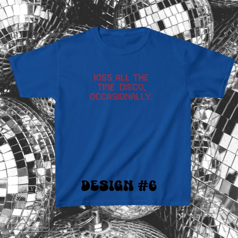 Puede incluir: Una camiseta de manga corta en color azul real con el texto rojo KISS ALL THE TIME. DISCO, OCCASIONALLY. y el texto negro DESIGN #6 impresos en la parte delantera. La prenda cuenta con un cuello redondo y un corte est&aacute;ndar sencillo.