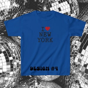 Puede incluir: Una camiseta de manga corta color azul real con el texto en negro I NEW YORK, donde un coraz&oacute;n rojo sustituye a la palabra LOVE. En la parte inferior de la camiseta aparece el texto en negro DESIGN #4 con una fuente retro, negrita y redondeada.