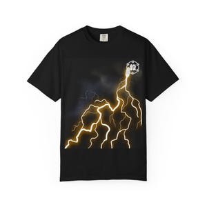 Op de afbeelding: Zwart t-shirt met een opvallend geel bliksemontwerp tegen een donkere, stormachtige achtergrond. Een klein, cirkelvormig embleem is rechtsboven zichtbaar. Het shirt is gemaakt van een zacht materiaal.