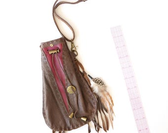 The Ember, uniek in zijn soort, leren talisman-/medicijnzakje, rode leren inleg, veren, inspirerende metalen bedel, sleutelclip en polsbandje.