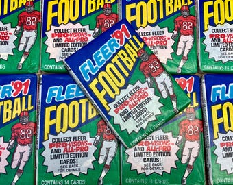 May include: Multiple packs of Fleer '91 Football trading cards. The packs are blue and green with the word "FOOTBALL" in large yellow letters. Each pack features a football player in a red uniform. The packs contain 14 cards.