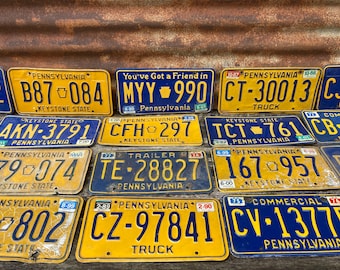 May include: A collection of vintage Pennsylvania license plates with yellow backgrounds and blue lettering. The plates feature various slogans, including "Keystone State", "You've Got a Friend in Pennsylvania", "Trailer", "Truck", and "Commercial".