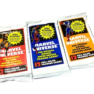 May include: Three unopened packs of Marvel Universe trading cards. Each pack features a different superhero illustration and the text "Marvel Universe." The packs are white with red, blue, and orange accents, and the text "Bonus Holograms!" is visible.