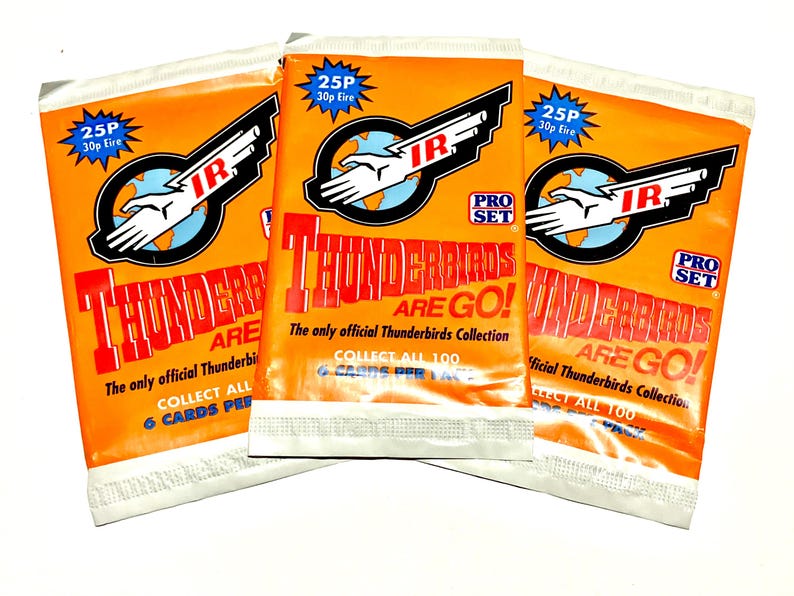 May include: Three orange foil trading card packs featuring the Thunderbirds Are Go logo, the Pro Set brand name, and the text The only official Thunderbirds Collection. Each pack displays a 25P price tag and indicates that there are 6 cards per pack.