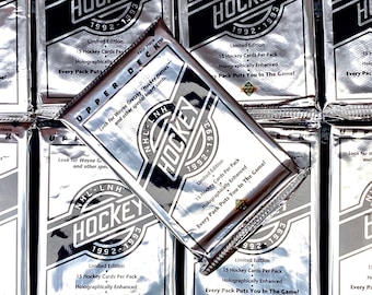 May include: Silver foil packs of 1992-1993 Upper Deck NHL Hockey cards. Each pack is a limited edition and contains 15 hockey cards. The packaging features the NHL logo and text that reads "Every Pack Puts You In The Game!"