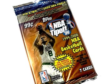 May include: A sealed Topps NBA Tipoff '99 basketball card pack. The pack features an image of a basketball player in a green and white uniform. The pack includes text that reads "NBA Tipoff '99" and "7 Cards".