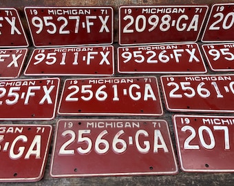 May include: Close-up of nine vintage Michigan license plates from 1971. The plates are red with white lettering and numbers. The plates feature different license plate numbers, including 9527 FX, 2098 GA, 9511 FX, 9526 FX, 25 FX, 2561 GA, 2566 GA, and 2076.