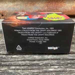 Puede incluir: Una caja negra con texto blanco que dice "Text &copy;CARDZ Distribution, Inc. 1993 Artwork &copy;TALES FROM THE CRYPT HOLDINGS 1993 TALES FROM THE CRYPT&trade; is a Trademark of TALES FROM THE CRYPT HOLDINGS. CARDZ Distribution, Inc. Grand Prairie, Texas 75050 Printed In USA 1993 OTHER CARDZ&trade;".