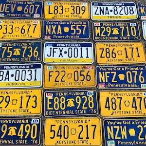 May include: A collection of 16 vintage Pennsylvania license plates in various colors and designs. The plates feature the state's name, the year of issue, and a variety of slogans, including "Keystone State" and "Bicentennial State".