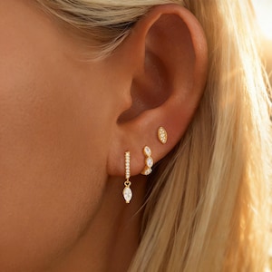 May include: A white ceramic mug with a black handle and the text "But First, Coffee" in a bold, black font. The mug is set against a neutral background, highlighting its simple design.