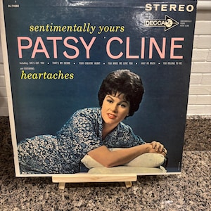 May include: Vintage Patsy Cline "Sentimentally Yours" album cover. The album cover is dark blue with the title in pink and the artist's name in pink. The album cover features a photo of Patsy Cline.