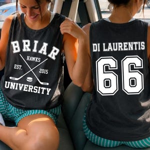 May include: Dark gray tank top with white text. The front displays "BRIAR HAWKS UNIVERSITY" with crossed hockey sticks and a puck. The back features "DI LAURENTIS" above the number "66" in white.