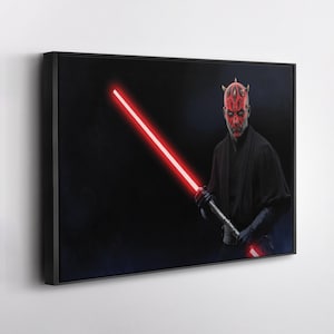 May include: Framed canvas art depicting a character with red face paint and horns, holding a glowing red lightsaber against a dark backdrop. The artwork is in a black frame.