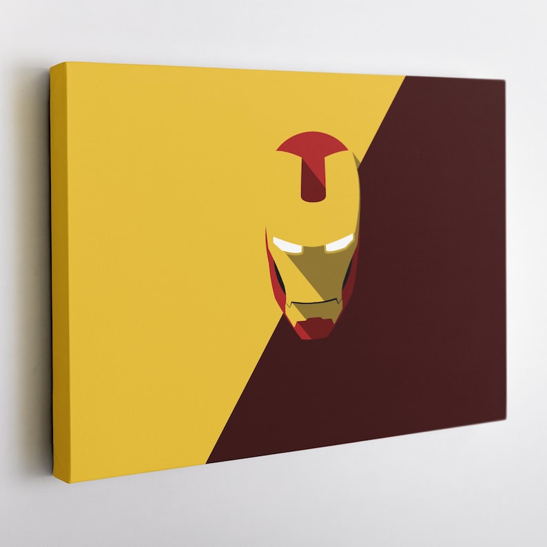 May include: A canvas art piece featuring a minimalist design of Iron Man's helmet. The artwork is split diagonally, with a yellow background on the left and a maroon background on the right. The helmet is yellow and red with white eye slits.