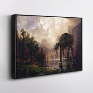 May include: Framed canvas art print featuring a landscape with a mountain range, lake, and forest. An AT-AT walker stands in the water. The artwork has a vintage style with a black frame.