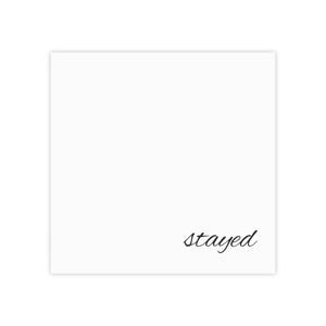 May include: A white square card with the word "stayed" in a cursive font in the bottom right corner. The text is in black. The card is plain and simple.
