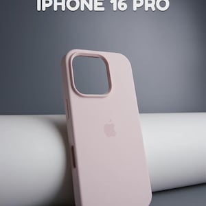 May include: A light pink silicone iPhone 16 Pro case. The case has a cutout for the camera and buttons, and features the Apple logo on the back. The text "SILICONE CASE" and "IPHONE 16 PRO" are displayed in white.