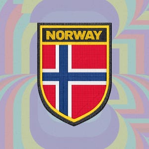 Puede incluir: Un parche bordado en forma de escudo con la bandera de Noruega, que presenta un fondo rojo, una cruz blanca y una cruz azul. La palabra NORWAY está bordada en letras mayúsculas amarillas sobre una franja rectangular negra superior.