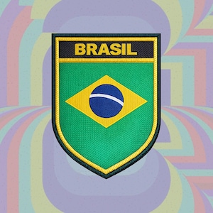 Puede incluir: Un parche bordado en forma de escudo con el diseño de la bandera de Brasil, que presenta un campo verde, un rombo amarillo y un círculo azul central con una banda blanca. La palabra BRASIL está bordada en letras amarillas sobre fondo negro.