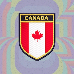 Puede incluir: Un parche bordado en forma de escudo con la bandera de Canadá, una hoja de arce roja centrada en una franja vertical blanca entre dos franjas verticales rojas. La palabra CANADA está bordada en letras doradas sobre una banda azul oscuro.