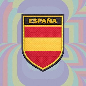 Puede incluir: Un parche bordado en forma de escudo con la bandera de España de franjas horizontales rojas y amarillas. La parte superior es una franja negra con la palabra ESPAÑA bordada en hilo amarillo. El parche tiene un borde negro grueso.
