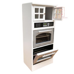 以下が含まれることがあります： 白のミニチュアキッチン家電。電子レンジ、オーブン、収納キャビネット付き。オーブンドアとキャビネットドアが開いており、内部が見えます。電子レンジには「12:00」と表示されています。この家電は、ドールハウスやミニチュア設定用に設計されています。