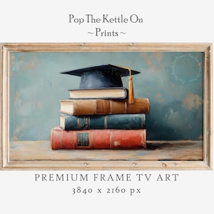 May include: A framed print featuring a stack of books topped with a graduation cap. The books are in shades of brown and red, with a blue-green background. The text "Pop The Kettle On ~ Prints ~" and "PREMIUM FRAME TV ART" are visible.