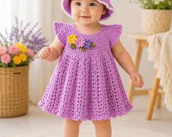 May include: A lavender crochet dress with flutter sleeves and a flared skirt, featuring a cluster of yellow, pink, and purple crochet flowers on the chest. The outfit includes a matching lavender crochet bucket hat with a white scalloped edge.
