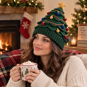 May include: A dark green crocheted beanie shaped like a Christmas tree, featuring a ribbed brim, layered branches, small red and blue spherical ornaments, a gold-colored garland, and a yellow crocheted star topper at the very peak of the hat.