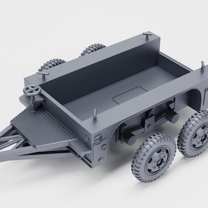 May include: A gray model of a military trailer with a rectangular cargo bed, a textured ramp, and two sets of wheels. The trailer has a steering wheel and various mechanical details, suggesting a scale model of a vehicle.
