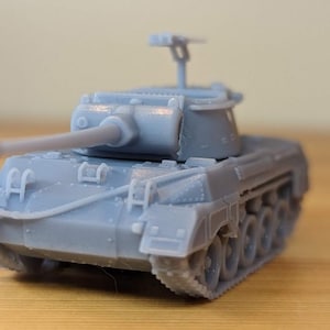 May include: A light gray toy tank with a long barrel and detailed treads. The miniature model features a turret, hatches, and other realistic elements. The tank is a miniature replica of a military vehicle.