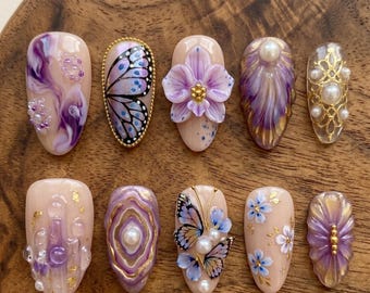 Uñas postizas de lujo color violeta púrpura con diseño de flor esculpida en 3D y mariposa dorada. Uñas personalizadas.