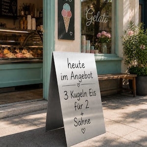 May include: An outdoor advertisement for an ice cream shop. The sign reads "heute im Angebot" and "3 Kugeln Eis für 2 + Sahne." A chalkboard menu lists ice cream flavors. A sign with an ice cream cone graphic hangs above the sign.